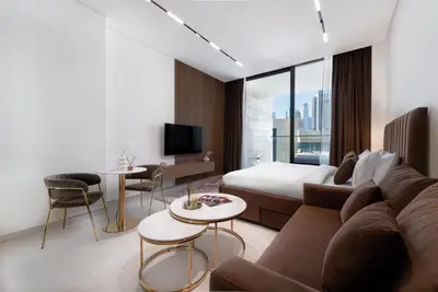 a hotel room with a couch and a bed at Studio Apartments with Private Jacuzzi - Spa - Cold Plunge - Gym in Business Bay in Dubai