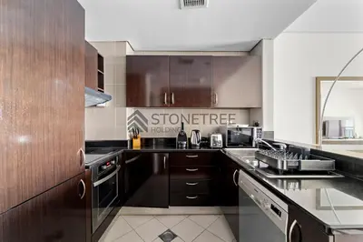 a kitchen with wooden cabinets and a counter top at Sea View 1BR - Private Beach Access Anantara in Dubai