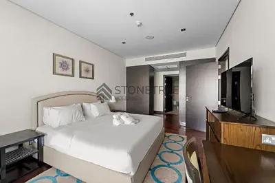 a bedroom with a bed and a flat screen tv at Sea View 1BR - Private Beach Access Anantara in Dubai