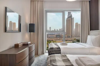 a hotel room with two beds and a large window at Luxury 4BR Burj Khalifa View Dubai Mall in Dubai