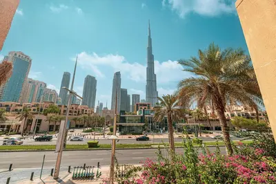 a city with tall buildings and palm trees and a street at Luxury 2BR in Dubai Downtown Steps to Burj Khalifa and Dubai Mall with Burj Khalifa View by La Brisa in Dubai