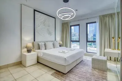 a white bedroom with a large bed and windows at Luxury 2BR in Dubai Downtown Steps to Burj Khalifa and Dubai Mall with Burj Khalifa View by La Brisa in Dubai