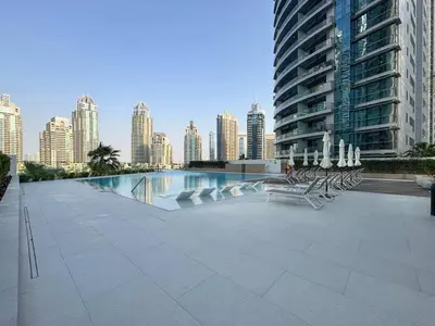 a swimming pool with chairs and a city skyline at Frank Porter - Liv Marina in Dubai