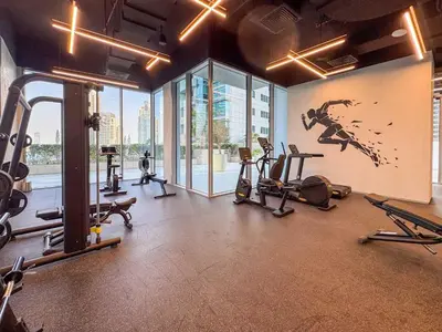 a gym with several tread machines and a painting on the wall at Frank Porter - Liv Marina in Dubai