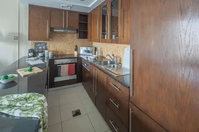 a kitchen with wooden cabinets and a sink and a stove at Frank Porter - Boulevard Walk Downtown in Dubai