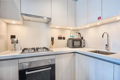 a kitchen with a stove and a sink at STAY BY LATINEM Luxury 1BR Plus Study Holiday Home CC 3109 Near Burj Khalifa in Dubai