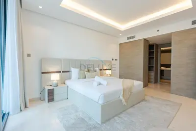 a white bedroom with a large bed and a desk at Burj Khalifa Views, Walking Distance to Dubai Mall and Downtown Boulevard - The Sterling West House, Business Bay by Deluxe Holiday Homes in Dubai