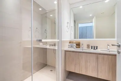 a bathroom with two sinks and a shower at Luxury Modern Home with Direct Park Access in Dubai