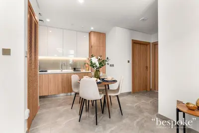 a kitchen and dining room with a table and chairs at Bespoke Holiday Homes - Elegant 2BR Waterfront Stay with Canal View in Dubai