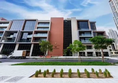 a large building with trees in front of it at Bespoke Holiday Homes - Elegant 2BR Waterfront Stay with Canal View in Dubai
