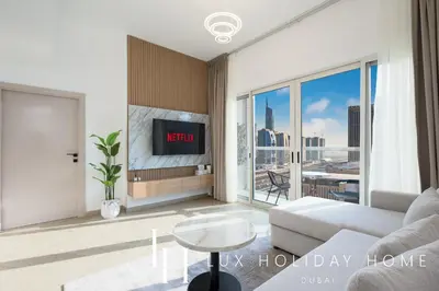 a living room with a couch and a tv at LUX The Marina View Suite 3 in Dubai