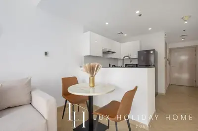 a living room with a table and a kitchen at LUX The Marina View Suite 3 in Dubai