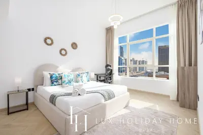 a white bedroom with a bed and a large window at LUX The Marina View Suite 3 in Dubai