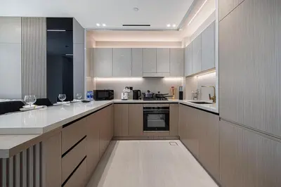 a large kitchen with white counter tops and appliances at Stylish Family Retreat That Sleeps 6 In The Heart of JVC in Dubai