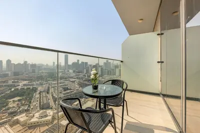 a balcony with a table and chairs and a city at Lush 1BR Apt at Bloom tower in JVC in Dubai