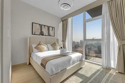 a bedroom with a large bed and a large window at Lush 1BR Apt at Bloom tower in JVC in Dubai