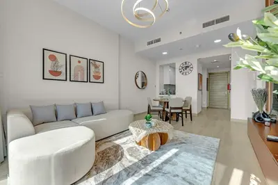 a living room with a white couch and a table at Lush 1BR Apt at Bloom tower in JVC in Dubai