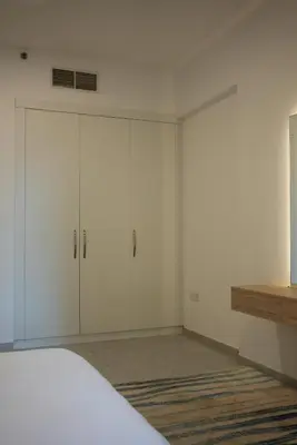 a white bedroom with white cabinets and a bed at Marjan Escape Studio in Dubai