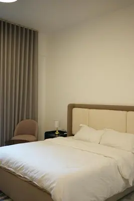 a bedroom with a large white bed and a chair at Marjan Escape Studio in Dubai