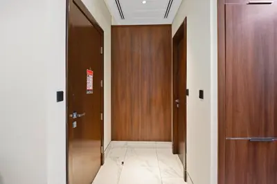 a hallway with two wooden doors and a tile floor at Relax in Comfort with Modern Amenities, Steps from Burj Khalifa and Dubai Mall in Dubai