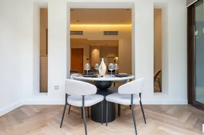 a dining room with a round table and chairs at Newly Refurbished Luxury Garden Apartment with Burj Khalifa View and Direct Pool Access in Downtown Dubai in Dubai