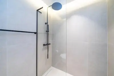 a shower with a glass door in a bathroom at Newly Refurbished Luxury Garden Apartment with Burj Khalifa View and Direct Pool Access in Downtown Dubai in Dubai