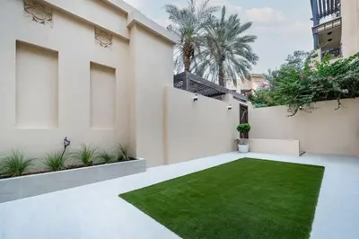 a courtyard with a green lawn in a building at Newly Refurbished Luxury Garden Apartment with Burj Khalifa View and Direct Pool Access in Downtown Dubai in Dubai