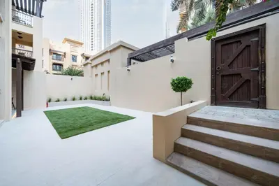 a courtyard with a door and a green rug at Newly Refurbished Luxury Garden Apartment with Burj Khalifa View and Direct Pool Access in Downtown Dubai in Dubai