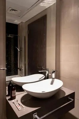 two white sinks on a counter in a bathroom at Modern Studio with Balcony, Stunning City Views & Free Parking, Close to Dubai Mall in Dubai