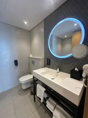 a bathroom with a sink and a toilet and a mirror at Novotel Residence in Dubai