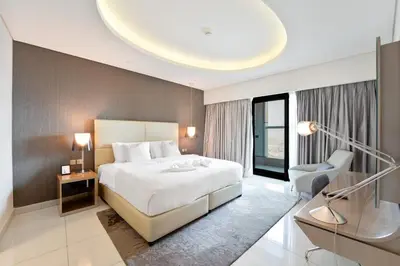 a bedroom with a large white bed and a chair at High-Rise Living - Paramount Tower - 1 bedroom in Dubai
