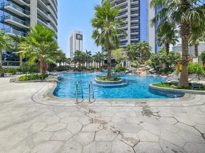 a swimming pool with palm trees in a city at High-Rise Living - Paramount Tower - 1 bedroom in Dubai
