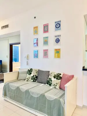 a room with a couch and some pictures on the wall at Peachy Mint - Luxury 1 BHK - Marina & Sea View in Dubai