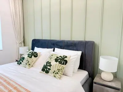 a bed with white pillows and a blue head board at Peachy Mint - Luxury 1 BHK - Marina & Sea View in Dubai