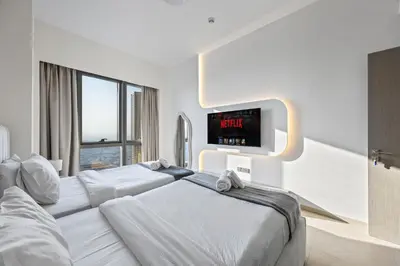 a hotel room with two beds and a flat screen tv at Elegant High-Rise Escape with sea view by SoleaStay in Dubai