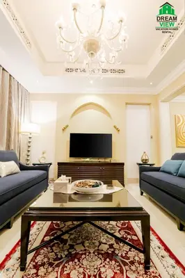 a living room with a table and a chandelier at Souk Al Bahar View Burj Khalifa and Fountains Dream View Holiday Homes in Dubai