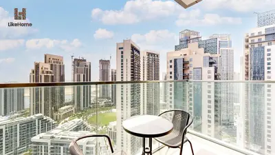 a balcony with a table and chairs and a city at Stylish2BR Apartment Iconic The Grand LH in Dubai