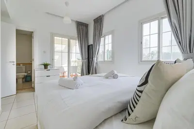 a white bedroom with a large bed and windows at The Springs 8 - 2 Bedroom with Maids Room Villa - Allsopp & Allsopp in Dubai