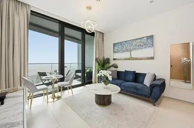 a living room with a blue couch and a table at Stylish Urban Stay in Address JBR with Canal View in Dubai