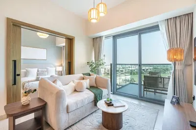 a living room with a couch and a large window at PVH - Modern 1BR with Golf Course View - Golf Gate in Dubai