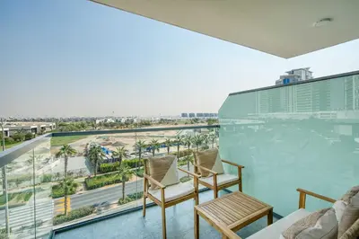 a balcony with two chairs and a view of the city at PVH - Modern 1BR with Golf Course View - Golf Gate in Dubai