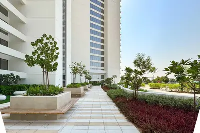 a walkway in front of a building with trees and plants at PVH - Modern 1BR with Golf Course View - Golf Gate in Dubai