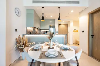 a dining room with a white table and chairs at PVH - Modern 1BR with Golf Course View - Golf Gate in Dubai