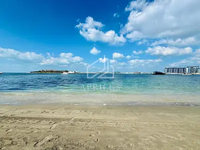 a beach with the ocean and buildings in the background at Cozy 1BD Apartment in Grand Bleu, Emaar Beachfront in Dubai