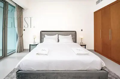 a bedroom with a large white bed with two tables at Stunning 2BR Holiday Home JBR Views Dubai Marina in Dubai