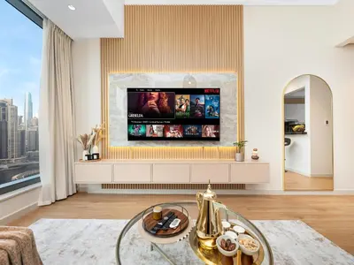 a living room with a flat screen tv on a wall at Livora Stays - Marina Promenade , Walk to JBR in Dubai