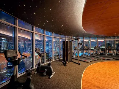 a gym with a view of a skyscraper at GuestReady - 2BR City View | Canal | High Floor in Dubai