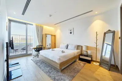 a bedroom with a bed and a mirror and a balcony at 1BR with Huge Terrace & Pool View at JVC in Dubai