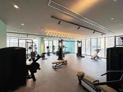 a gym with treadmills and exercise equipment in a building at 1BR with Huge Terrace & Pool View at JVC in Dubai