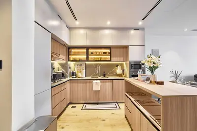 a kitchen with wooden cabinets and a counter top at 1BR with Huge Terrace & Pool View at JVC in Dubai